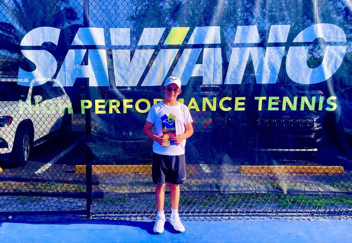 Alex holding a trophy at a Saviano High Performance Tennis tournament