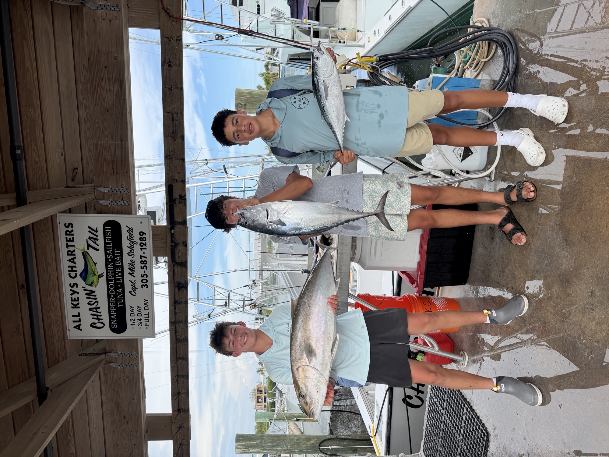 Alex and friends holding fish they caught on a Keys fishing charter, at the dock